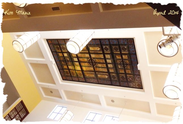 A stained glass window in the center of the sanctuary ceiling. 